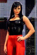 Dark haired Aksana posing seductively and smirking evilly