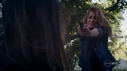Chloe pointing a gun at Samantha