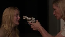 Andrea holding Melissa at gunpoint
