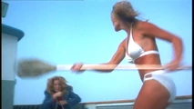 Henchwoman Caroline Field (Dorrie Thomson) attacking Lacy Bond (Sondra Currie) with a paddle aboard the boat.