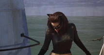 Catwoman is stunned as she sees Batman climbing back up to the submarine deck!