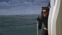 Catwoman stealthily observes Batman battle Penguin