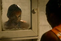 Olivia washes her face and sees a Demonic Olivia with an open Glasgow smile.