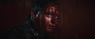 Beth emerges from the blood-filled elevator.