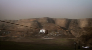 A transit pod running along a suspended cable between destinations.