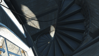 The spiral staircase from the second floor leading up to the top floor