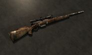 The hunting rifle with the scope, custom bolt, and extended magazine modification