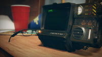 Le Pip-Boy 2000 Mark VI posé sur un bureau.