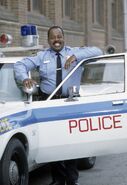 Carl Winslow (smiling) outside the cop car