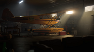 Carmina in the hangar at Rye & Sons Aviation in a cutscene.