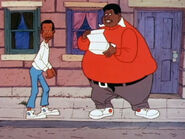 Fat Albert reading a folded sheet of paper while Bill cautiously looks around