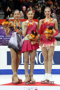 The ladies podium at the 2007-2008 ISU Grand Prix Final. Kim Yu-Na (1st, center) with Mao Asada (2nd, left) and Carolina Kostner (3rd, right).