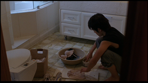 Tae-Suk doing laundry in the home he occupies.
