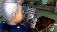 Station Officer Steele looking at an old newspaper page of one of his achievement's