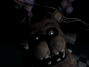 Withered Freddy che fissa la telecamera nella Stanza delle Feste 3, senza luci.