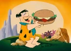 Fred eating a Bronto-Burger in an autographed sericel by Bill Hanna and Joe Barbera.