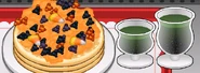 A plate of pancakes and two drinks
