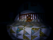 The Freddy plushie sitting on the bed.