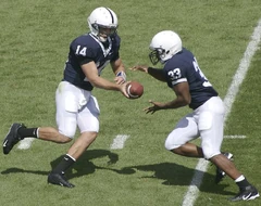   #14 Anthony Morelli hands the ball off to his  #33  in their  season opener.