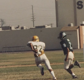 A high school cornerback (#8) in single coverage using the "loose man" technique.