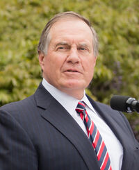Color head-and-shoulders photograph of Bill Belichick wearing a black tuxedo and black tie.