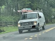 The 2009-2013 Ford E-350 Cargo Van Exterior Shown in Oxford White equipped with the High-Series Exterior Upgrade Package with A Sliding Passenger Side Door, Rear Swing Out Windowed Cargo Doors and 16" Steel Wheels with Sport Wheel Covers