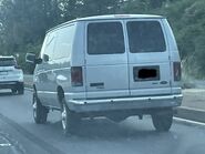 The 2012-2013 Ford E-350 XLT Passenger Van Exterior shown in Ingot Silver Metallic with Swing out Passenger Side Cargo Doors, Rear Swing Out Cargo Doors and 16" Steel Wheels with Full Sport Wheel Covers