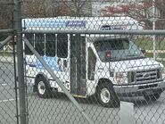 The 2015-2018 Ford E-350 Cutaway Van Exterior shown in Oxford White equipped with the High-Series Exterior Upgrade package with a Passenger Side Door Deleted and 16" x 7" White-Painted Steel Wheels used on Coach and Equipment Phoenix ML Shuttle Buses