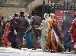 Extras in costume entering the castle.