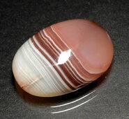 Reddish brown banded agate cabochon.