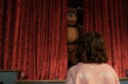 A cut scene of Piper, as Abby, looking at Freddy on stage.