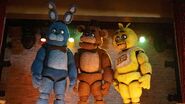 Bonnie, Freddy, and Chica on stage looking to their right.