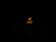 The third teaser of the Halloween update featuring nothing but the Freddy plush that sits on the bed. Nightmarionne's eyes are barely visible in darkness.