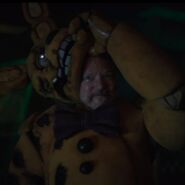 Steve Raglan/William Afton taking off the Yellow Rabbit's head, revealing himself.