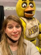 Crew member taking a photo with Chica.