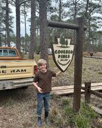 Grant Feely standing by the Covered Pines Campgrounds' sign.