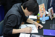 Kim Kwang Hyun, at a promotional event for the Freezing manga in Japan, drawing  