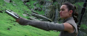 Rey présentant le vieux sabre laser à Luke Skywalker.