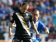 Dimitar Berbatov holds off a challenge from Wigan's Iván Ramis