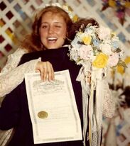 Michelle and Jim bob on their wedding day. Jim Bob is facing away from the camera and Michelle is looking over his shoulder, winking at the camera, while she holds their wedding certificate up.