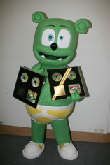 A Gummibär mascot costume holding golden records from Greece awarded by 