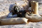 Entrenched Syrian soldier in a gas mask during a gas attack
