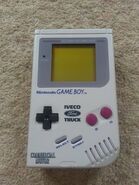 A Game Boy with the Iveco Ford Truck on it and Commerical Motor written on the bottom left of the Game Boy