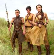 Three of the Sand Snakes, Oberyn's daughters. From left to right: Obara Sand, Tyene Sand, and Nymeria Sand. The different Sand Snakes wear a mix of revealing soft dress pieces with pieces of leather armor, leather riding leggings and boots.