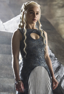The more subdued dress that Daenerys wears for formally receiving supplicants in her throneroom in Meereen. It also has a somewhat "scaley" embroidery pattern throughout, with a circular chest cutout and bits of exposed skin peaking through the embroidery pattern. Note her mother's ring on her left index finger.