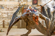 Daenerys climbing onto Drogon.