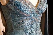 Closeup of an exhibition Daenerys's riding costume, focusing on the heavy embroidery design meant to visually evoke dragon-scales.