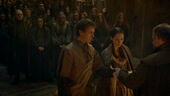 Edmure and Roslin join hands, which the septon begins wrapping a ribbon around.