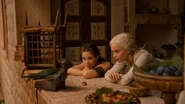 Daenerys uczy Drogona piec mięso.