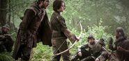 A guy teaches Arya how to properly use a bow in "The Climb".